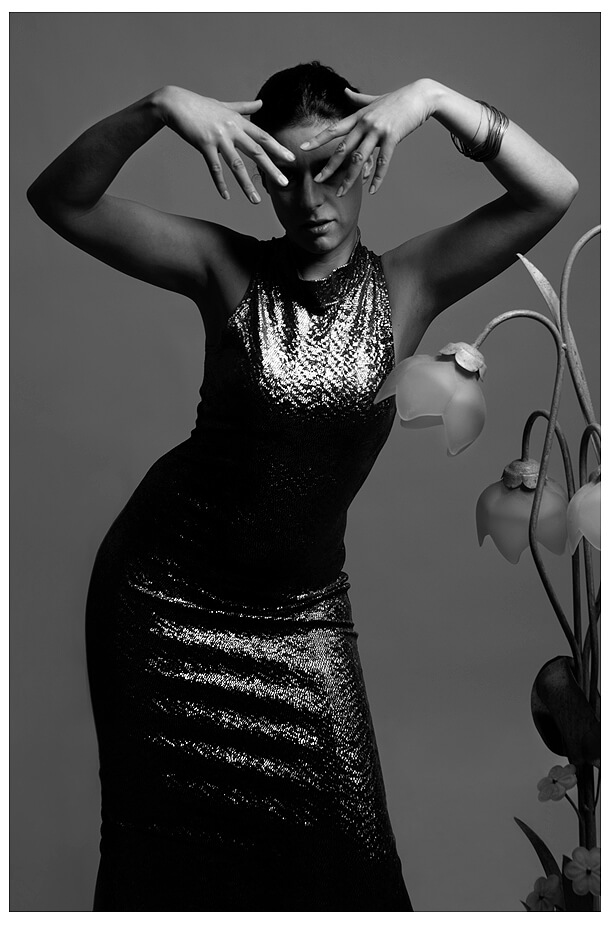 beauty_fotostudio_model schwarzweiss mit lampe kreuzt ihre hände vor dem Gesicht