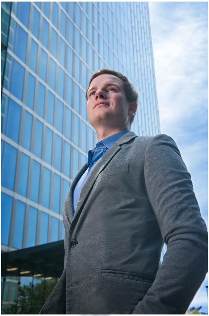 businessportrait muenchen boss schaut in die ferne vor dem glas stahl gebäude von Siemens