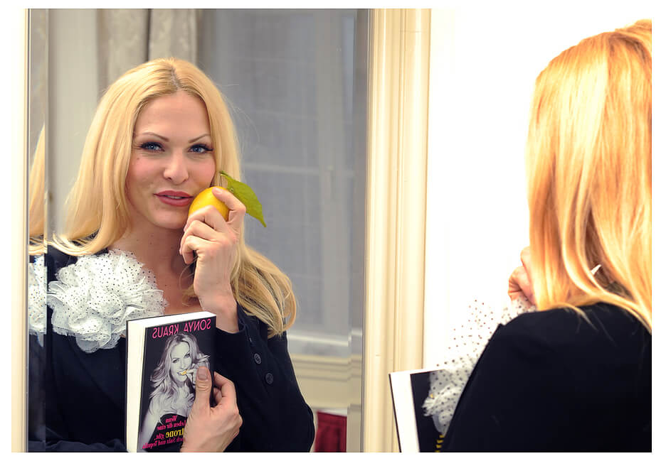 event fotograf Sonya Kraus mit Zitrone in der Hand im Spiegel mit ihrem Buch
