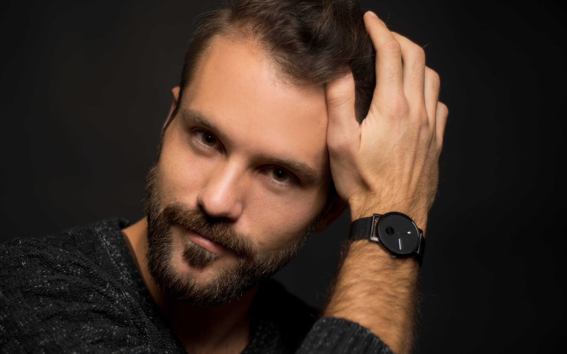 Ein Mann mit Bart und Armbanduhr zeigt sich stolz auf einem Social-Media-Foto