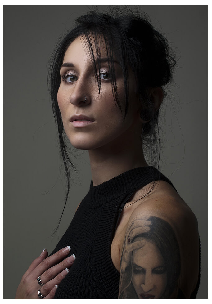 Eine Frau mit Tätowierung vom Marylin Manson auf den Armen posiert für ein Foto. Fotografie für soziale Medien