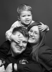 Familienfoto im Fotostudio Belichtungswert München mit Eltern und kleinem Kind, natürliches Familienportrait mit Nähe, Freude und lebendiger Ausstrahlung.