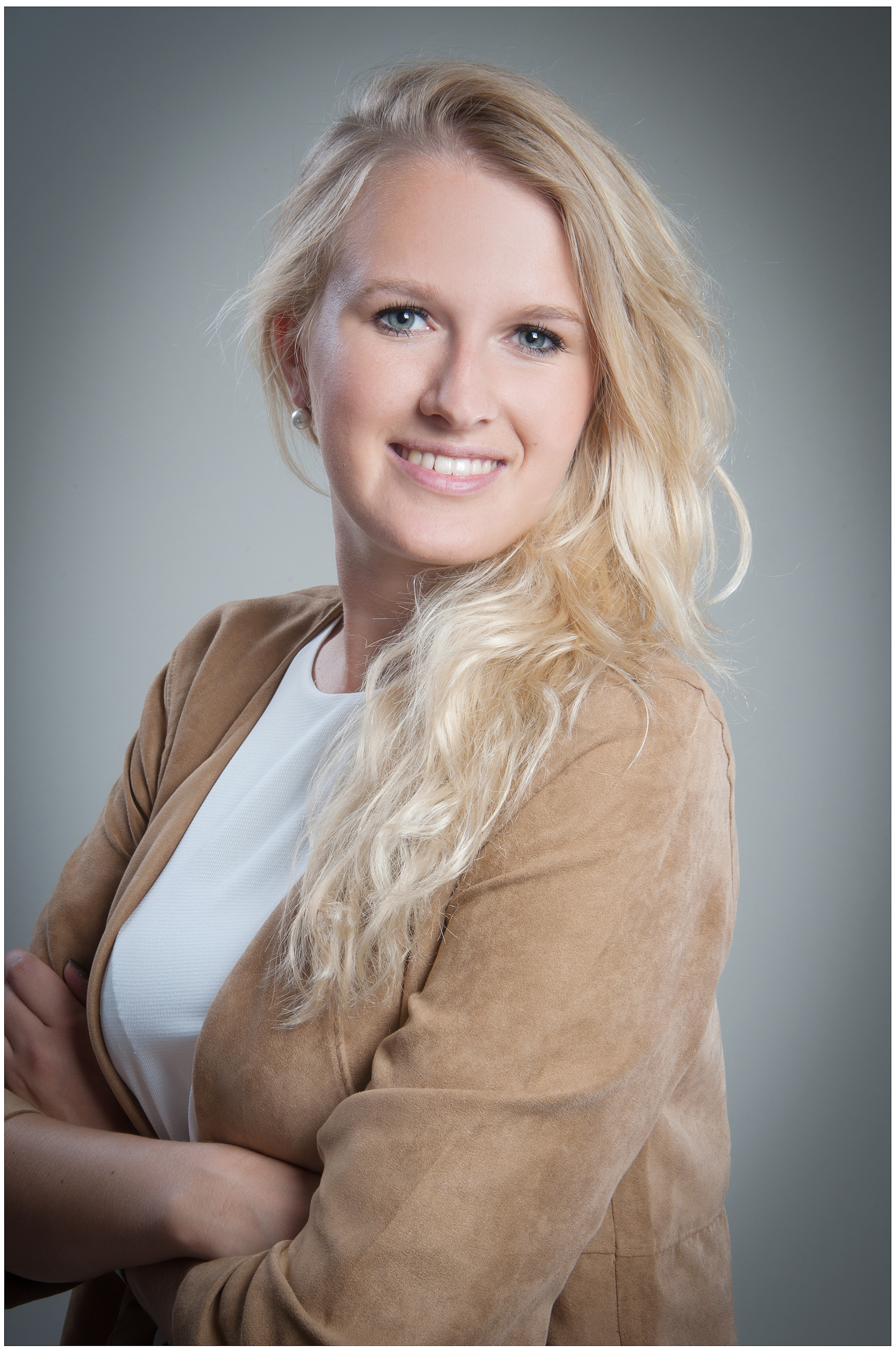 natürliche-komparsin-mit-blonder-haar-und-beiger-jacke-lächelt-im-studio