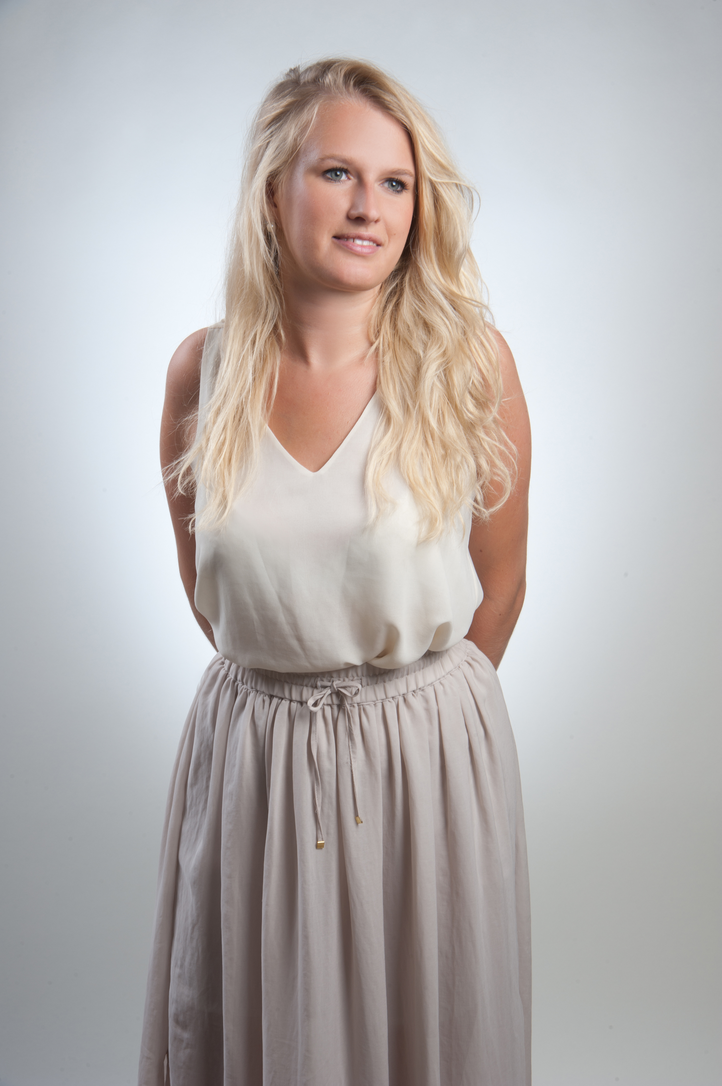 ganzkoerperfoto-komparsin-blonde-frau-in-beigem-outfit-vor-hellem-hintergrund