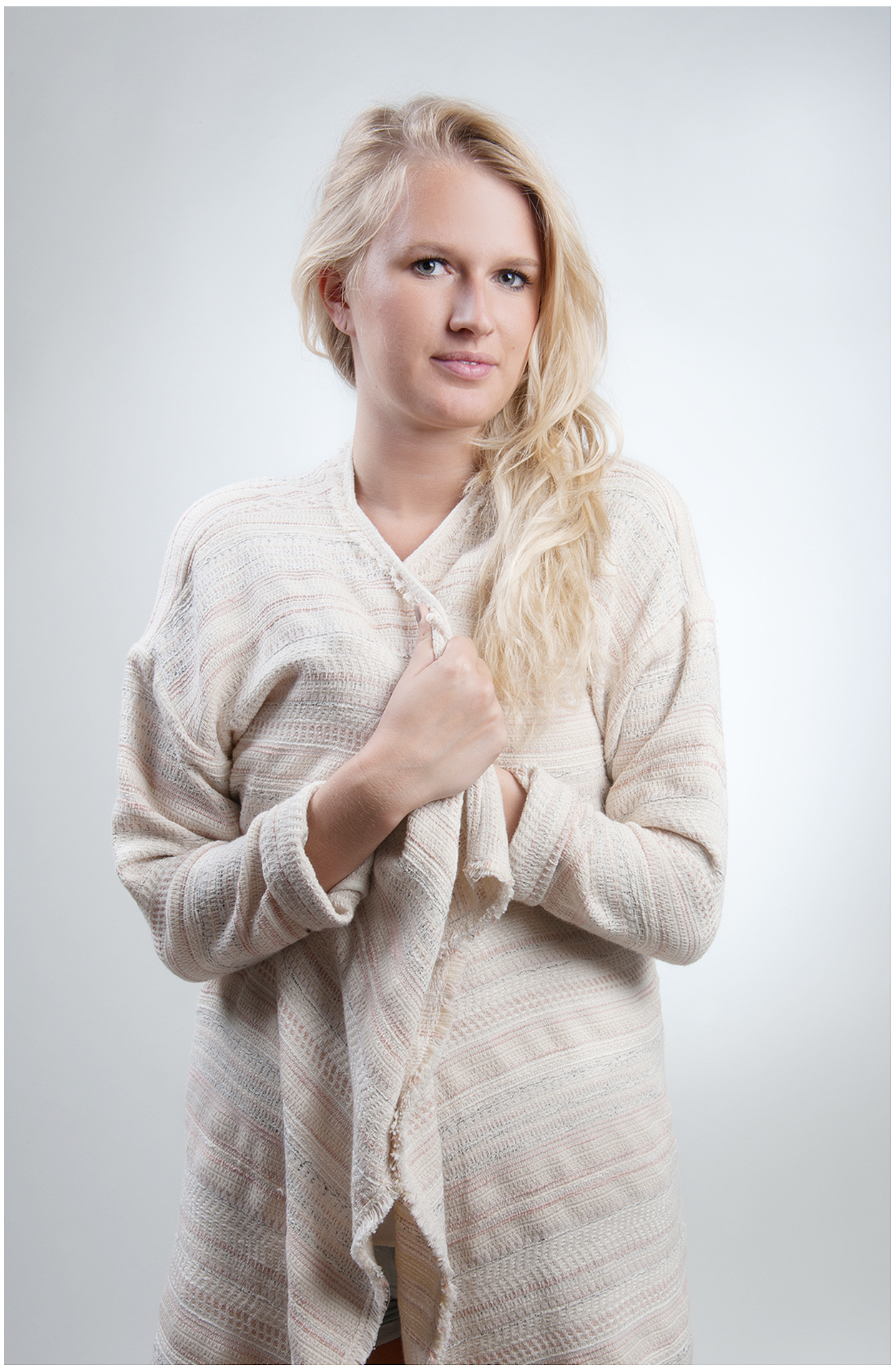 komparsin-portrait-blonde-frau-in-weichem-strickcardigan-natürliches-licht