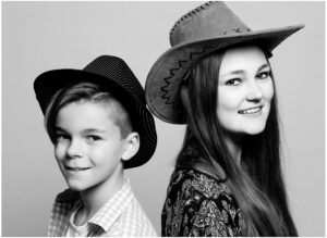 Schwarz-Weiß Geschwisterportrait im Fotostudio Belichtungswert München mit zwei Kindern in Cowboyhüten, natürliches Familienfoto mit spielerischer Ausstrahlung und modernem Studiolook.