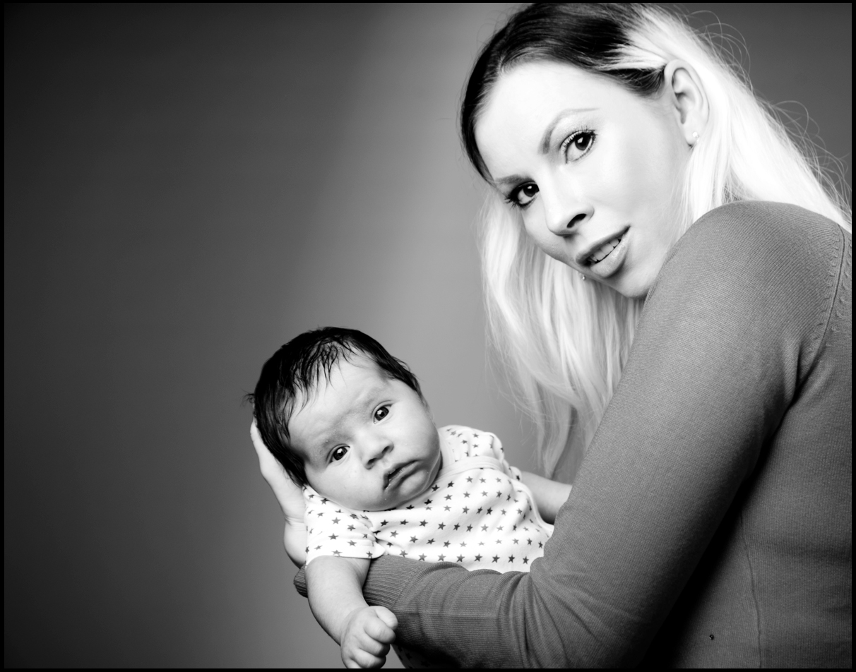 Das Bild zeigt eine Frau, die ein Baby in ihren Armen hält.