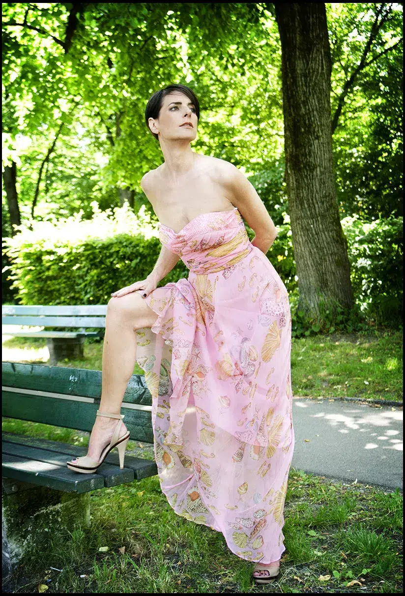 Beauty Fotoshooting im Studio und Outdoor junge Frau Rosa Kleid Bein auf der Bank