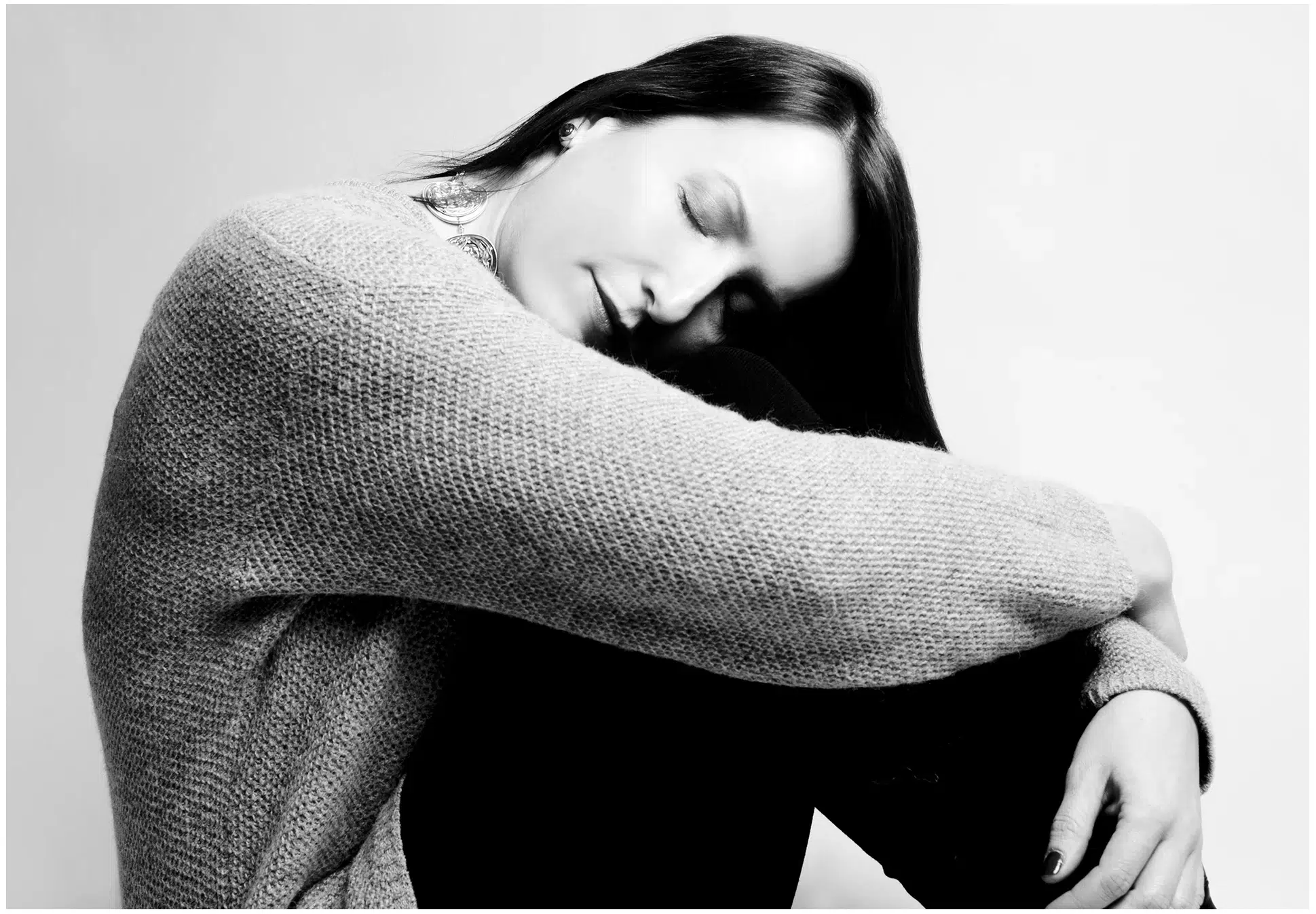 Bild einer Frau, die auf dem Boden sitzt und die Arme verschränkt hat