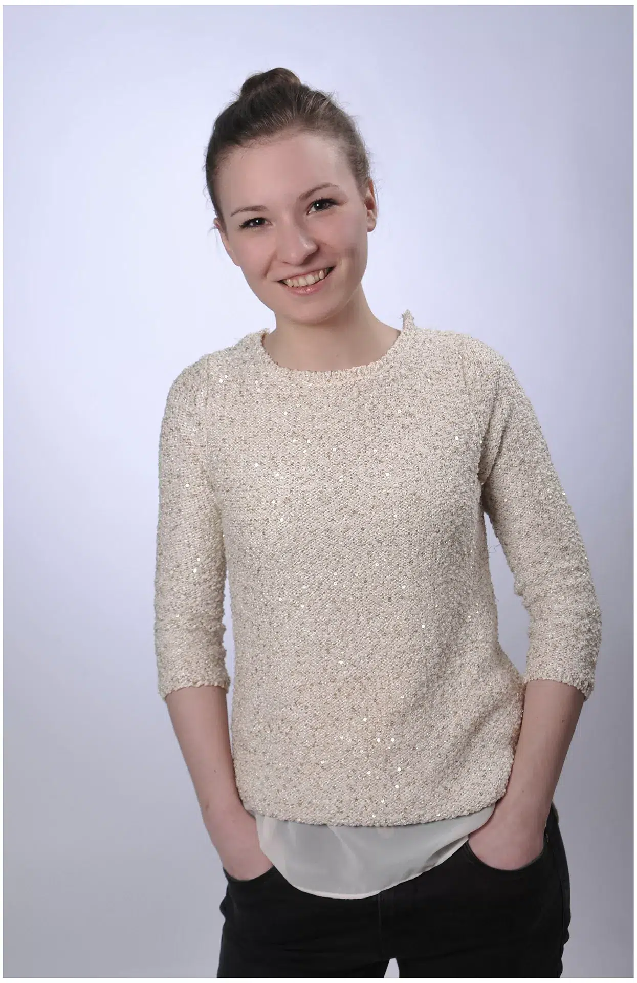 moderne Bewerbungsfotos junge Frau mit viel laecheln, helle Kleidung Pulli mit Glitzer