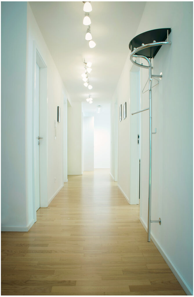 Heller Büroflur mit Holzparkett und Garderobe, minimalistische Räumlichkeiten Fotografie für die Firma in München