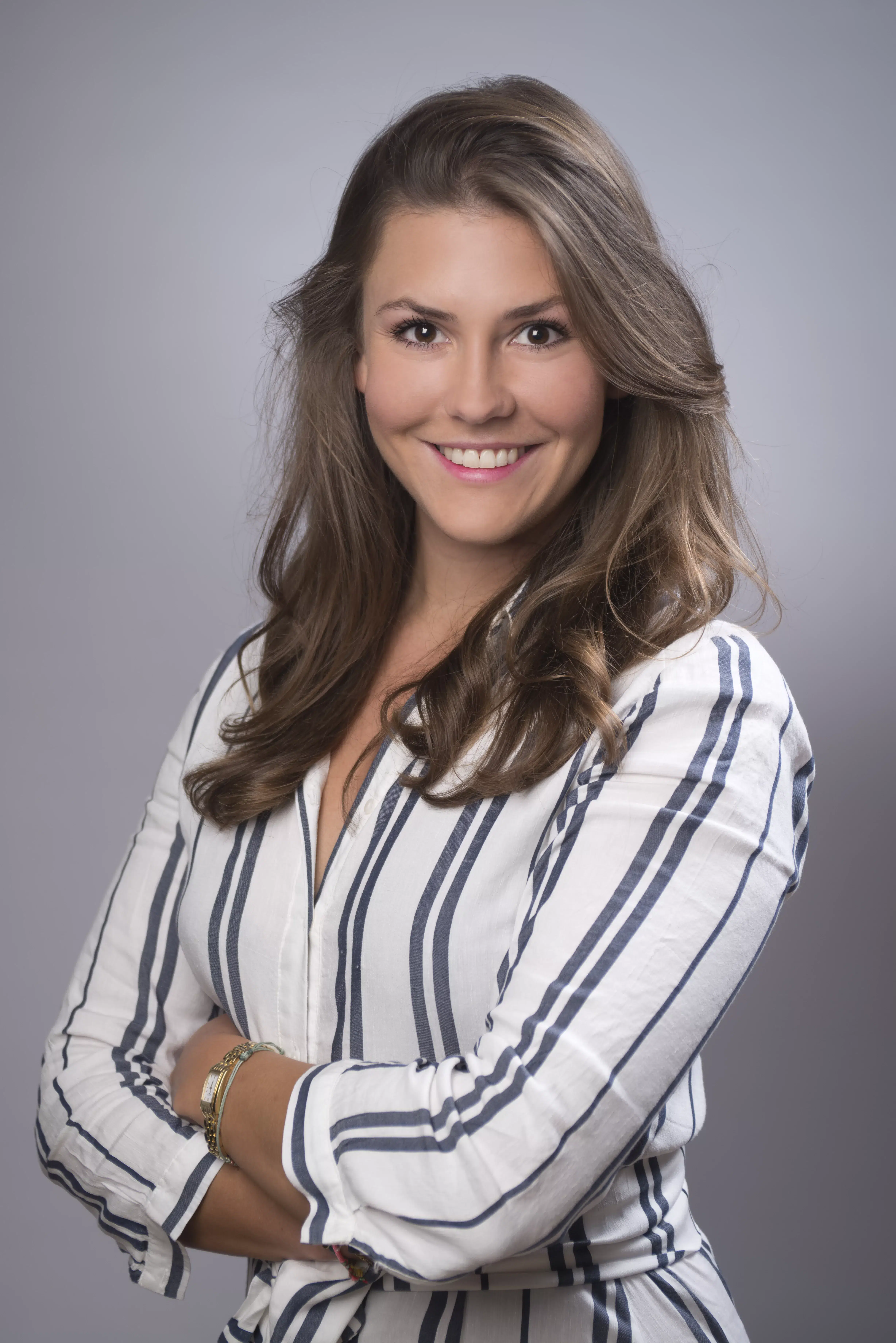 Junge Frau schaut in die Kamera, Businessportrait outdoor, gestreifte Bluse
