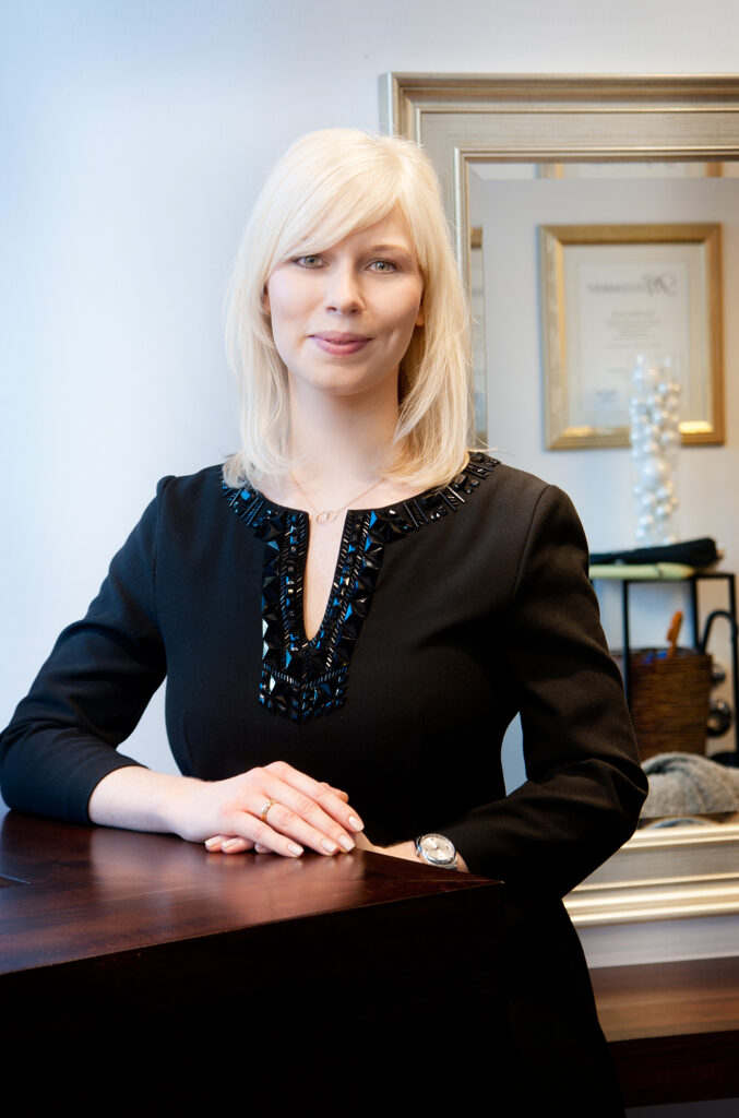 Businessportrait einer Stylistin im Friseursalon: blond, schwarzes Kleid, souveräne Ausstrahlung – Businessfotografie München