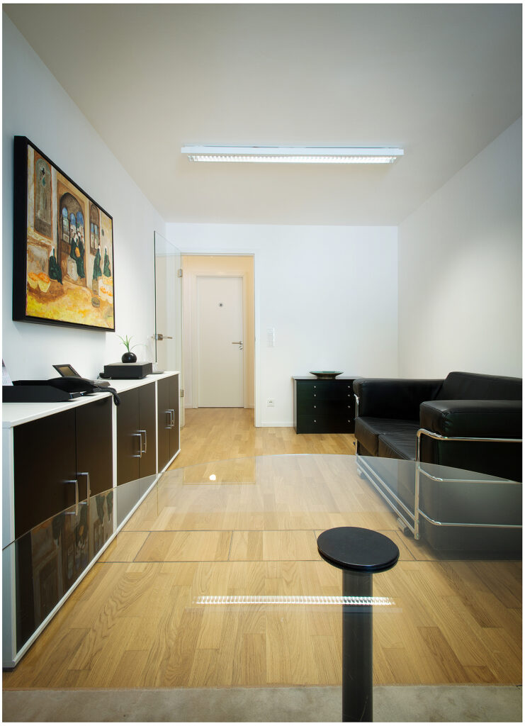 Empfangsbereich mit Sofa und Glastisch, klare Linien im Interior, Räumlichkeiten Fotografie für die Firma in München