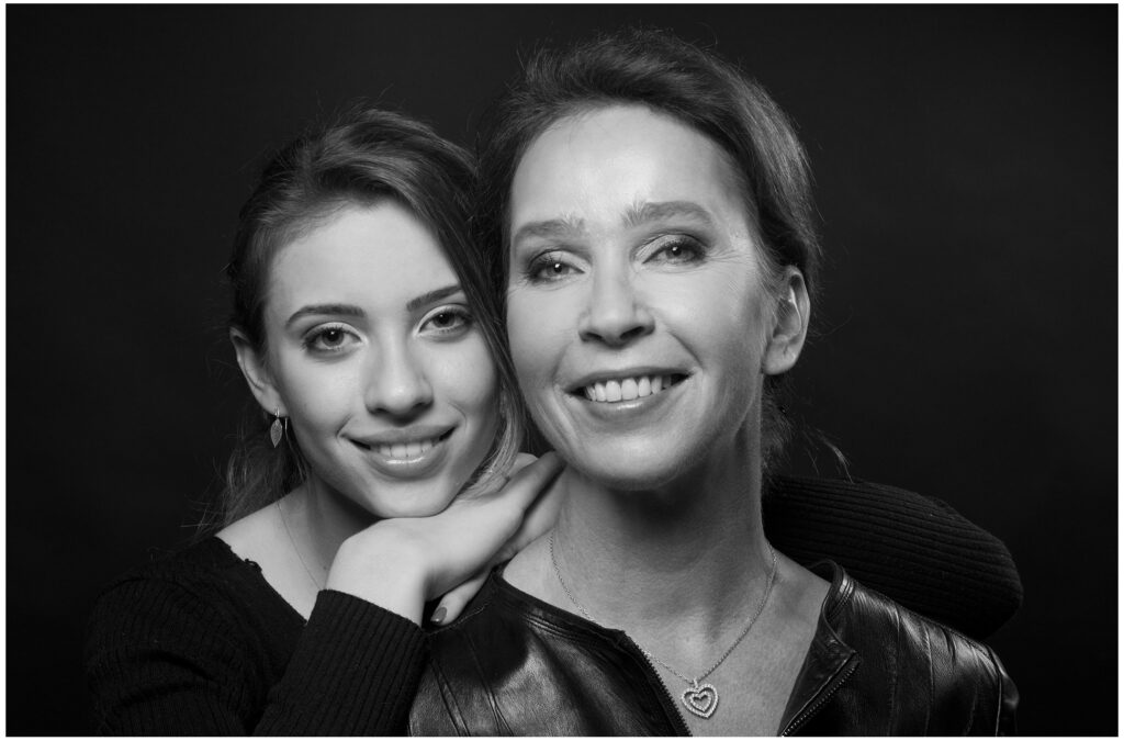 Emotionales Mutter-Tochter-Portrait als Familienfoto im Fotostudio mit ruhigem schwarzem Hintergrund