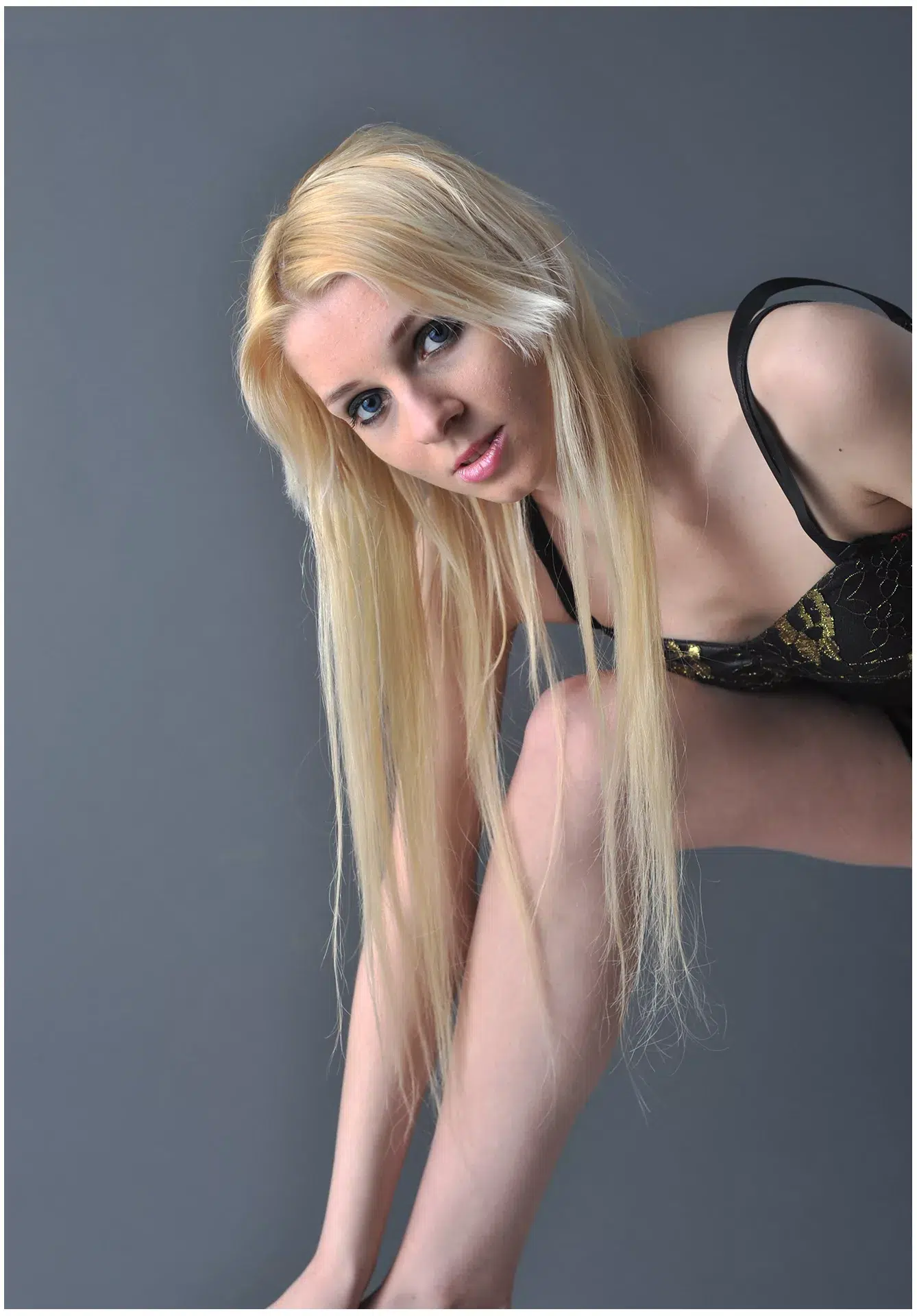 Junge blonde Frau steht, dunkler Hintergrund
