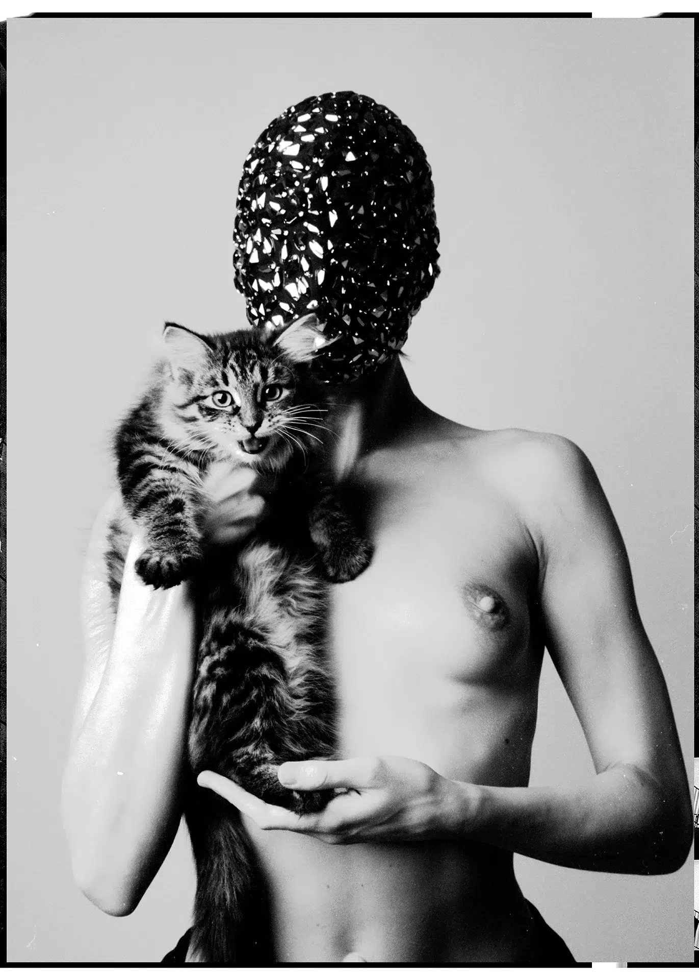 Model in einer Spiegelmaske mit der Katze am Arm