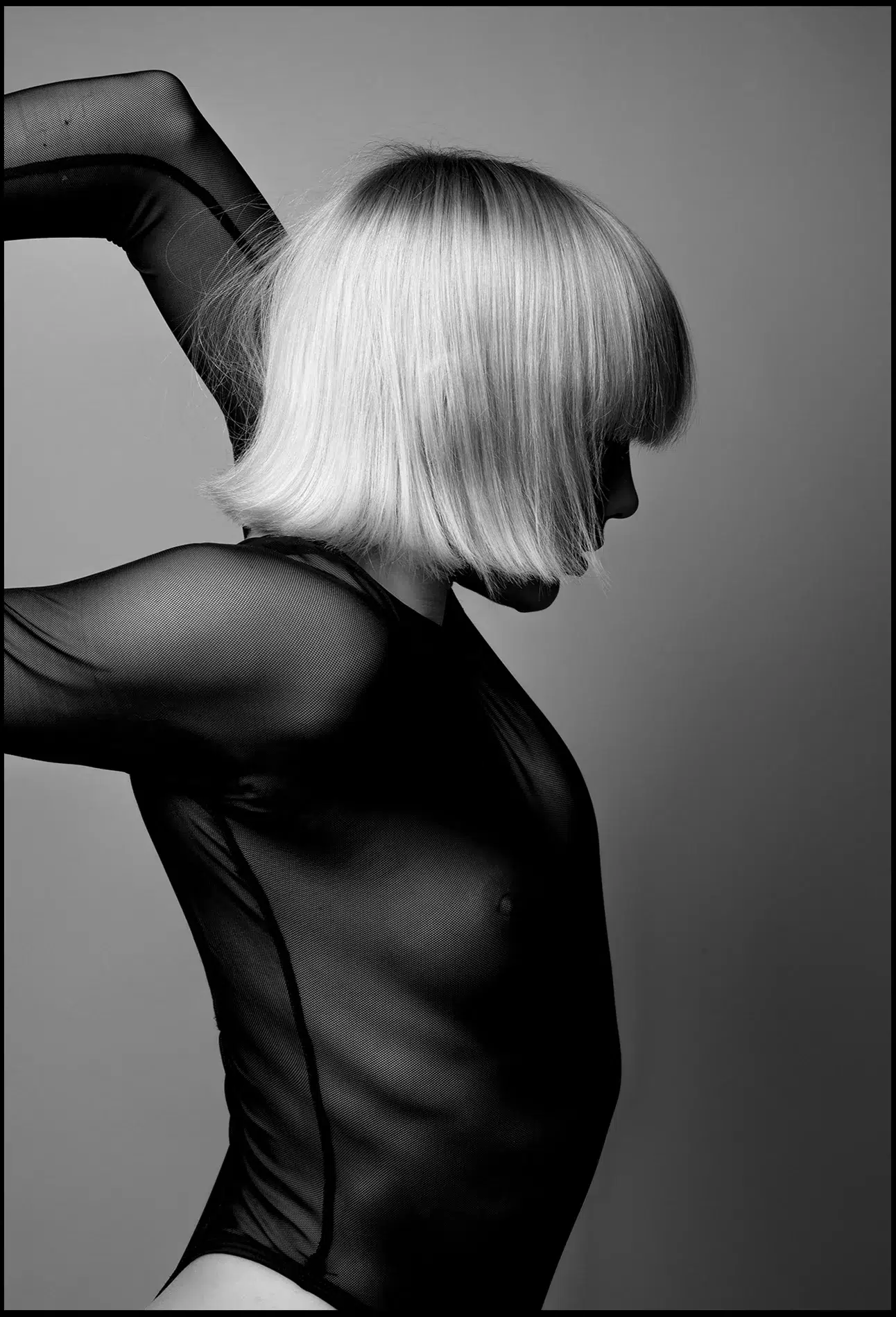 Blondes Model im schwarzen transparenten Top, seitlich, verdreht Hände