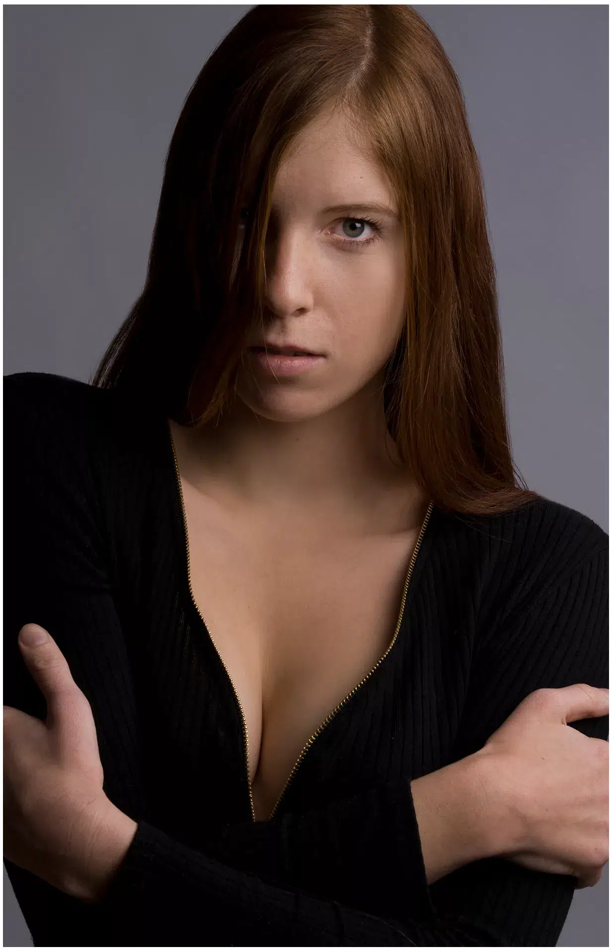 Rothaariges Model schaut frontal, ein Auge ist mit den Haaren bedeckt