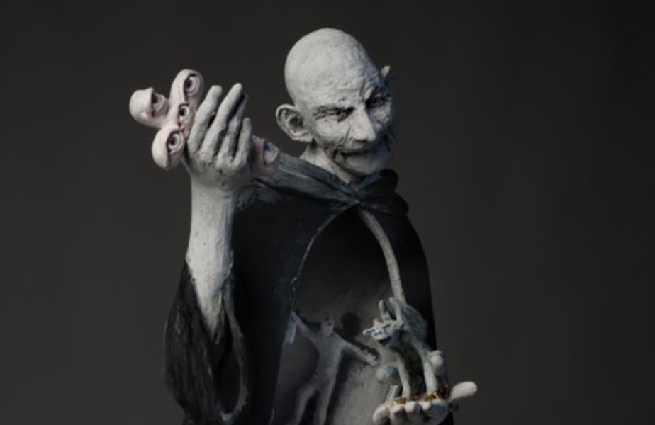 Produktfotografie vom Fotostudio Belichtungswert München, detailreiche Skulptur für eine Ausstellung mit dunklem märchenhaftem Charakter, surrealer Figur, Masken in der Hand und geheimnisvoller Theaterwirkung