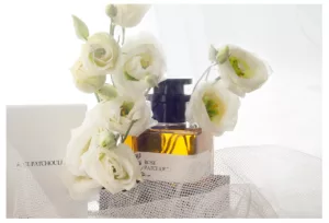 Parfum Flasche, dekoriert mit Stoff, heller Hintergrund, Objektfoto