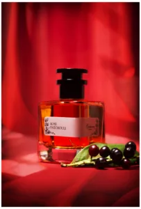 Parfum Flasche, dekoriert mit Beeren, roter Hintergrund, Objektfoto
