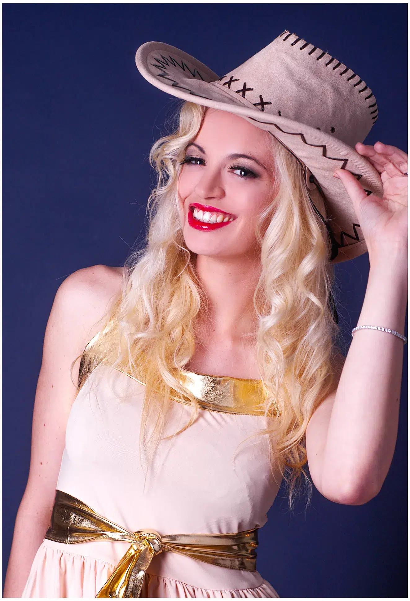 Blondes Model Antonia, blauer Hintergrund, Cowboy-Hut, lächelnd für Sedcard-Shooting