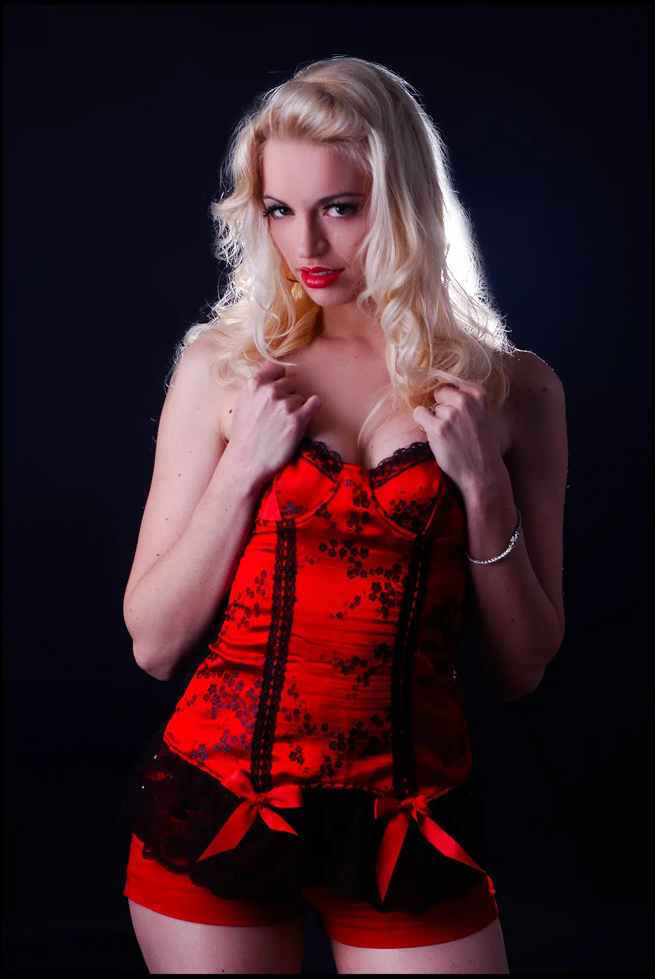 Blondes Model Antonia, sexy schwarzen Hintergrund, roter Corsage